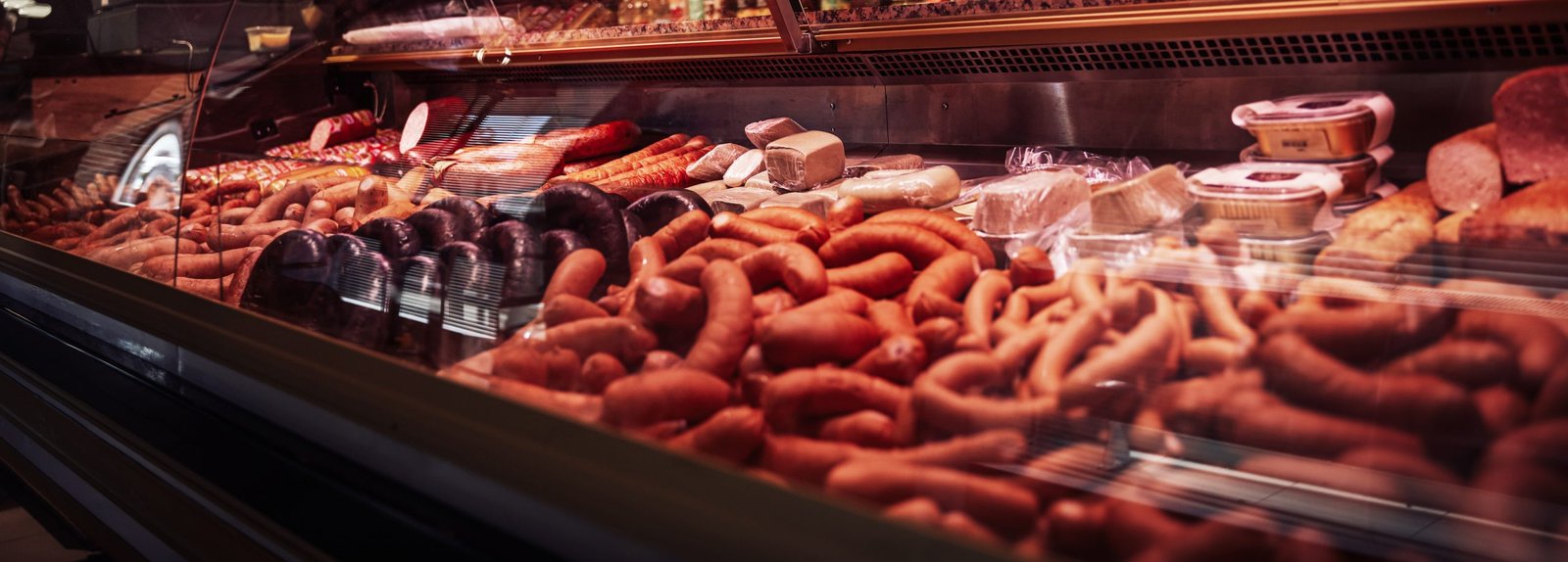 Fashionable and dark butcher shop. Meat saling business. Different and cool meat in the refrigerator indoors.